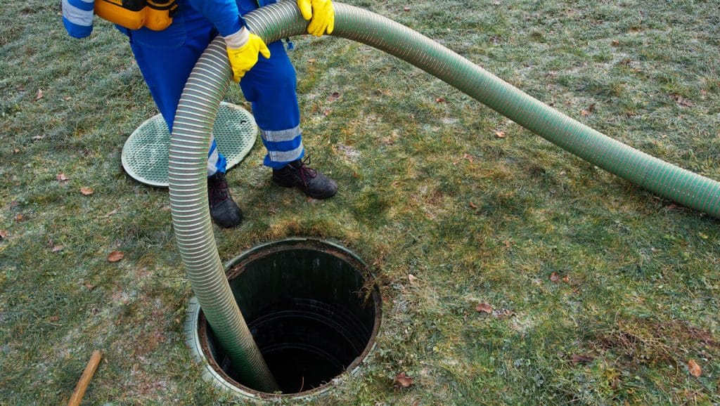 Image of a septic expert, pumping a septic tank.