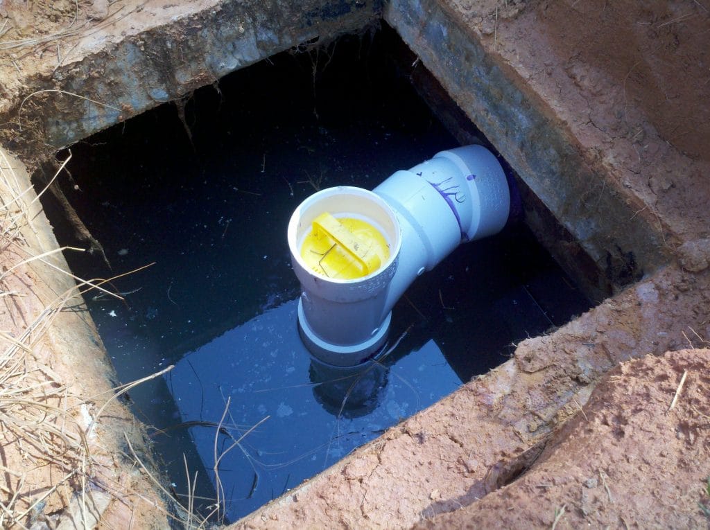 Image of what role a septic tank baffle plays in leach field lines.