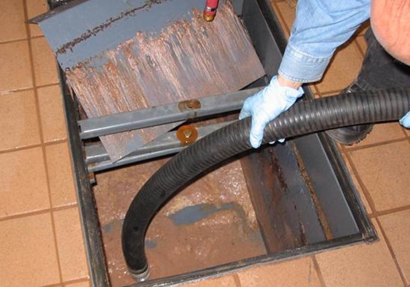 Image of a school grease trap being suctioned.