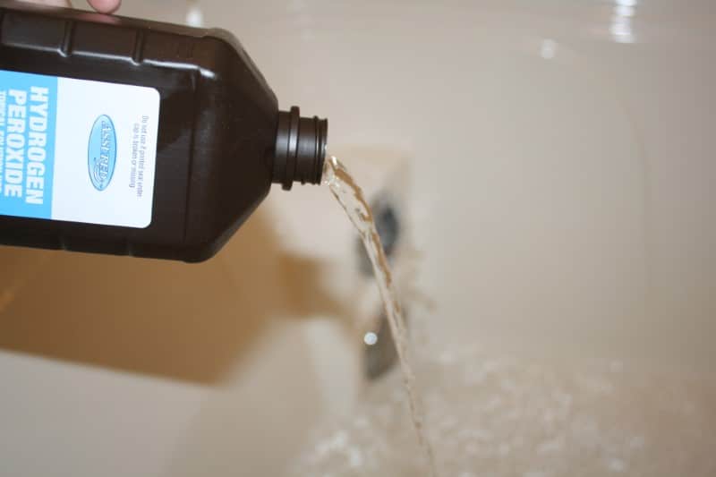 Image of hydrogen peroxide being poured into the drain.